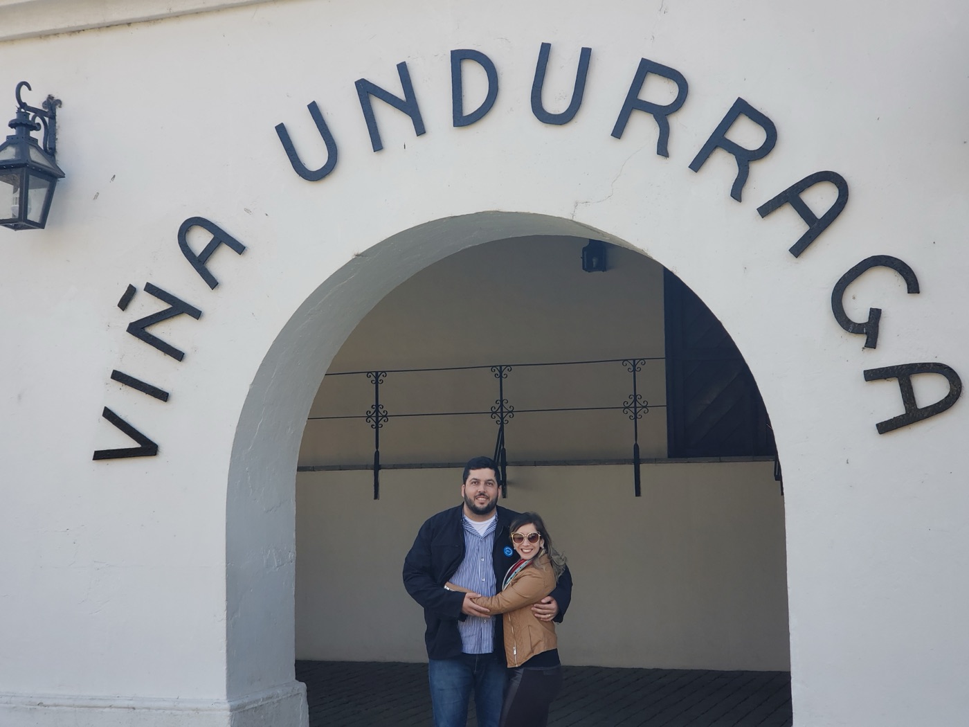 Arco de entrada da Viña Undurraga, com o nome da vinícola sobre a fachada branca